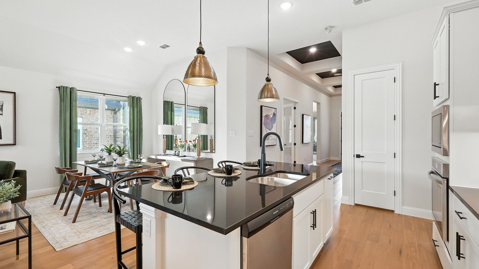 Sleek black countertops and luxurious hardwood floors make this kitchen a standout in Green Oaks Preserve.