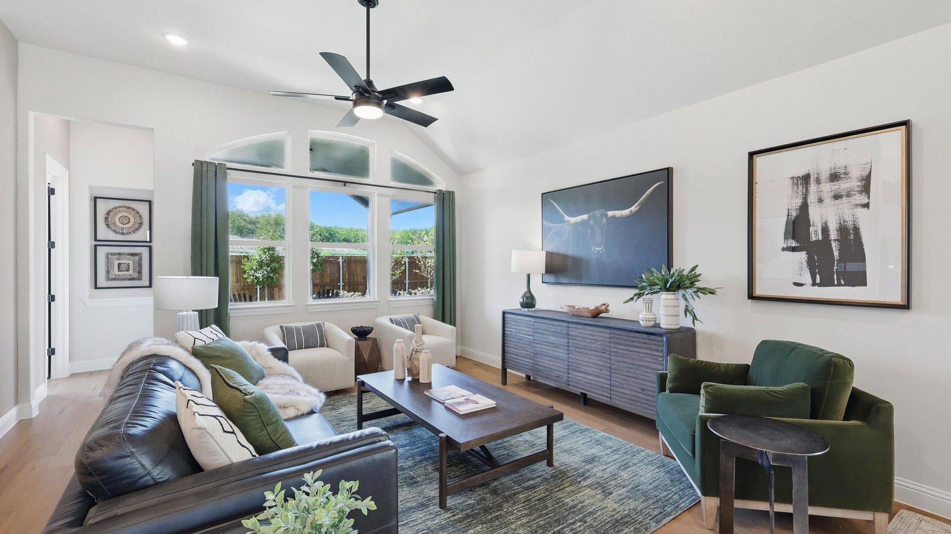 Experience sophistication with vaulted ceilings and arched windows in Green Oaks Preserve’s modern living area.