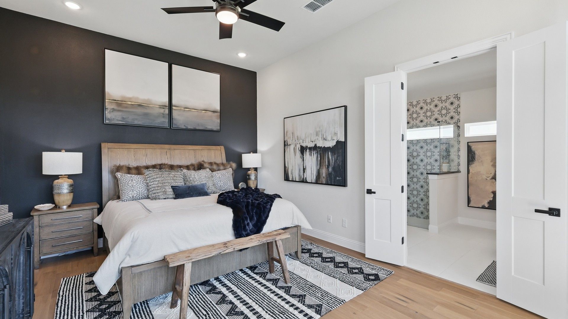 Luxurious bedroom with bespoke wood accents and chic ensuite bathroom in Green Oaks Preserve.
