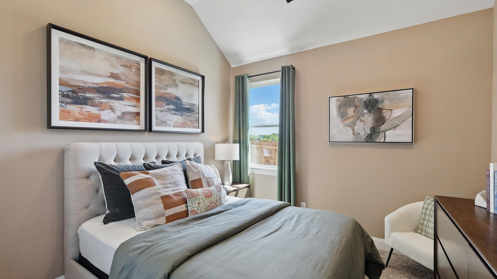 Vaulted ceilings and plush bedding highlight this Green Oaks Preserve bedroom's refined elegance.