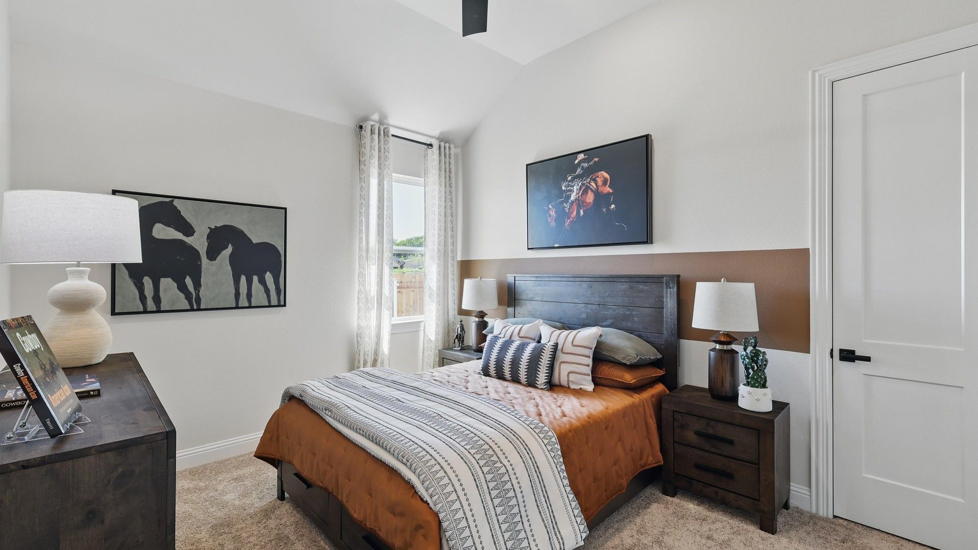 Experience vaulted ceilings and tasteful horse artwork in this refined Green Oaks Preserve bedroom.