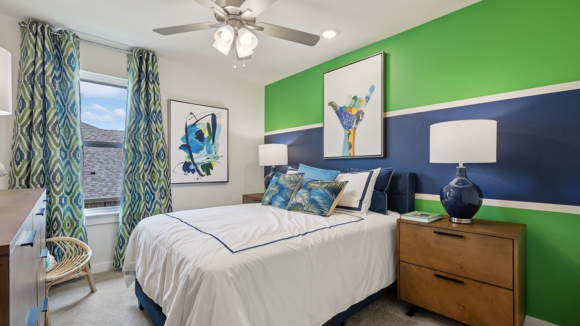 Churchill's vibrant bedroom boasts abstract art, stylish ceiling fan, and richly hued accent wall.