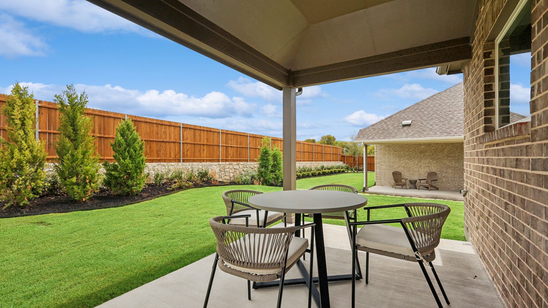 Elegant covered patio with chic seating and pristine landscaping in Churchill.