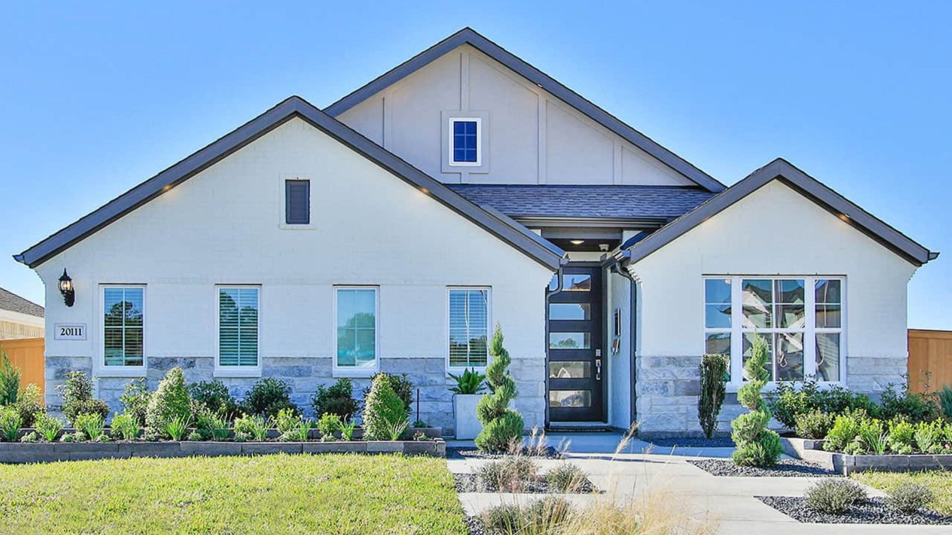 Elegant Cypress Green home features sleek stone accents and expansive windows, offering a refined living experience.