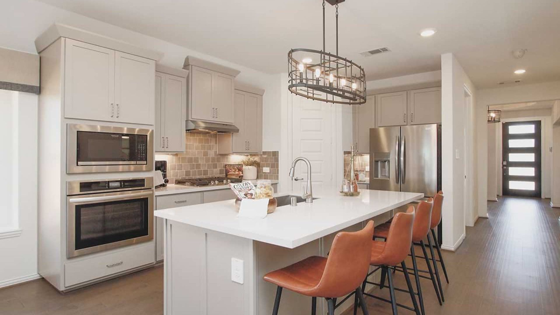 Cypress Green gem features elegant cabinetry, island bar, sleek pendant lighting, and luxurious hardwood floors.