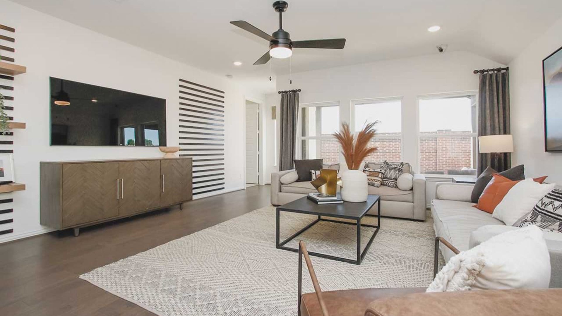 Luxurious living room in Cypress Green featuring a chic striped wall, stylish furnishings, and expansive windows.