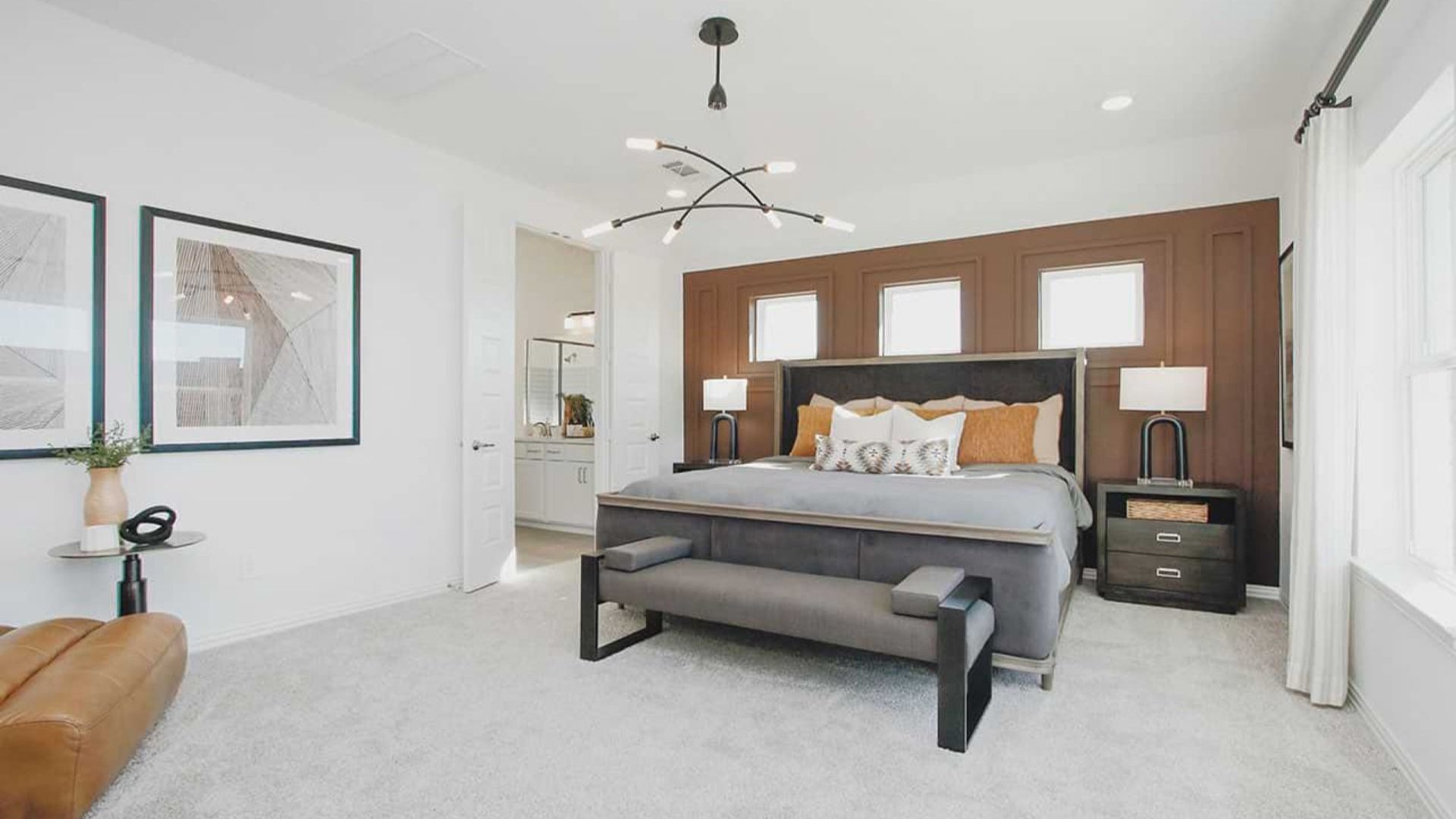 Luxurious bedroom with rich wood accent wall, stylish chandelier, plush carpet in Cypress Green.