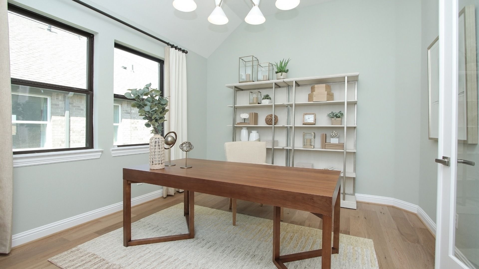 Elegant office with sleek wooden desk and expansive windows in Sunterra community.