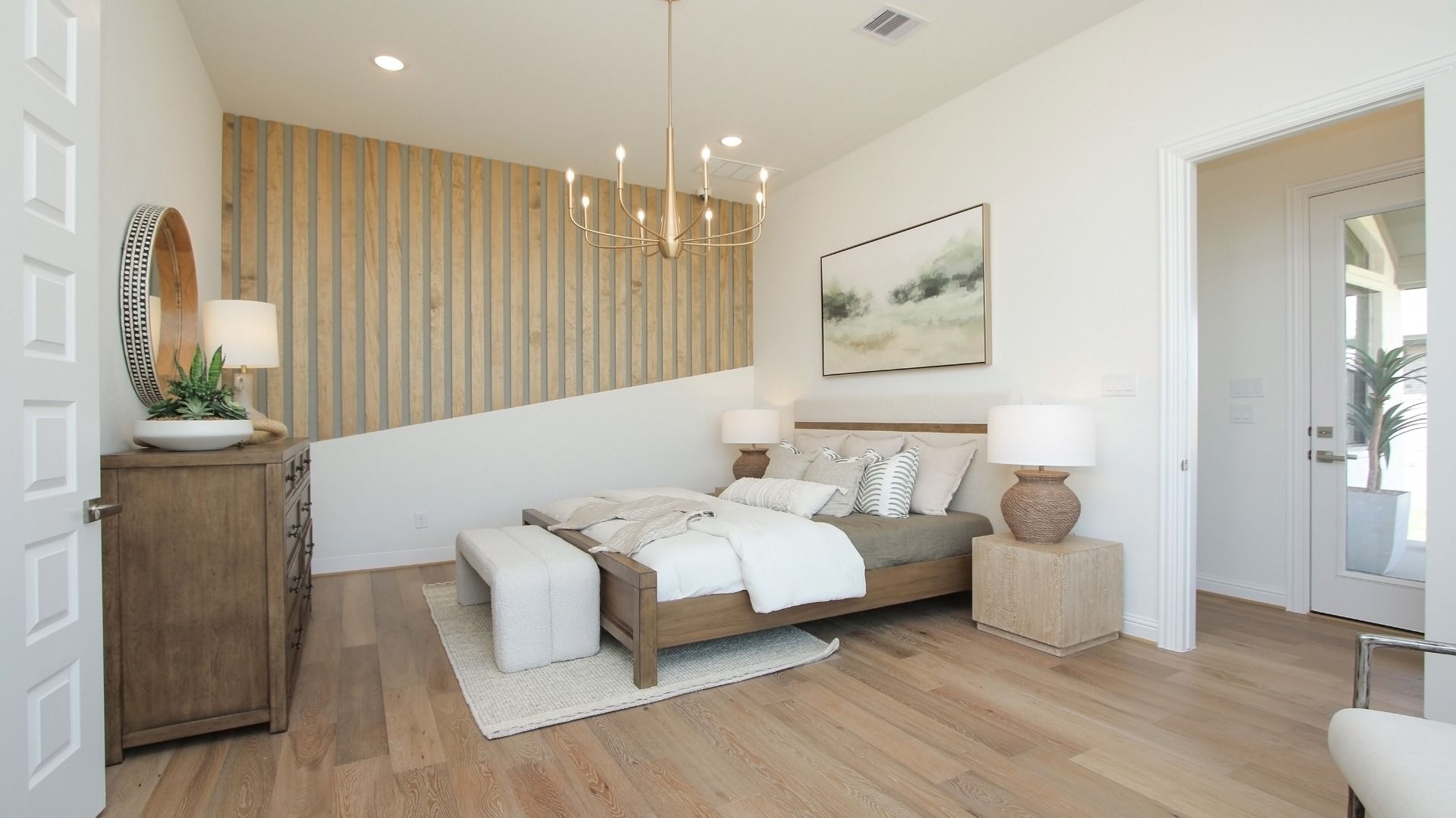 Luxury Sunterra bedroom boasts a tray ceiling, sophisticated accent wall, and plush bedding for a serene retreat.