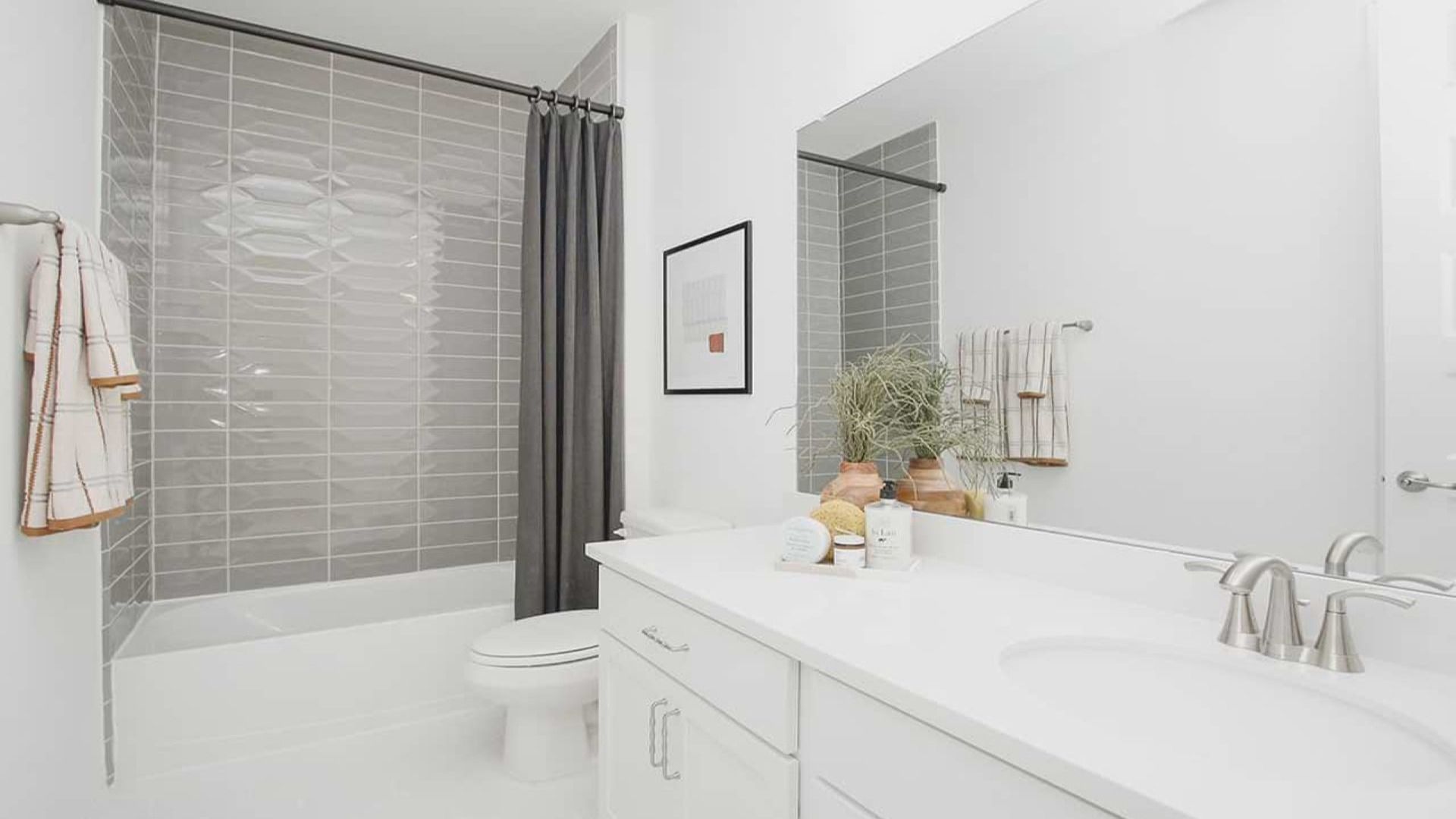 Luxurious bathroom features sleek white vanity, stylish gray tile, and premium fixtures in Cypress Green.