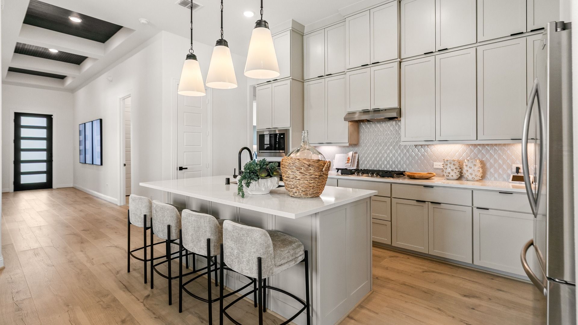 The kitchen is beautifully visible from the entryway, highlighting the home’s open and connected design.