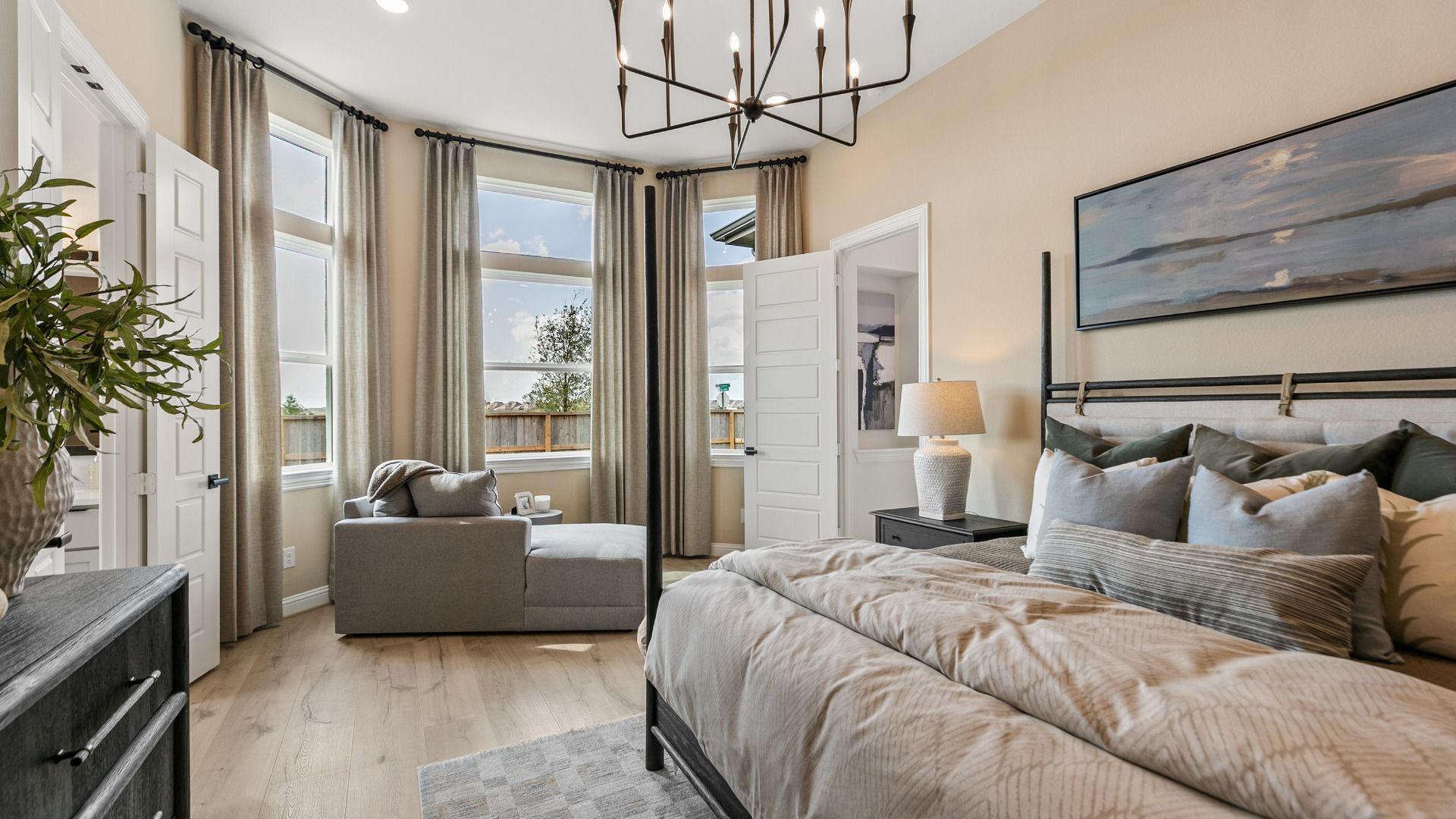 A bright primary suite featuring large windows that fill the space with natural light.