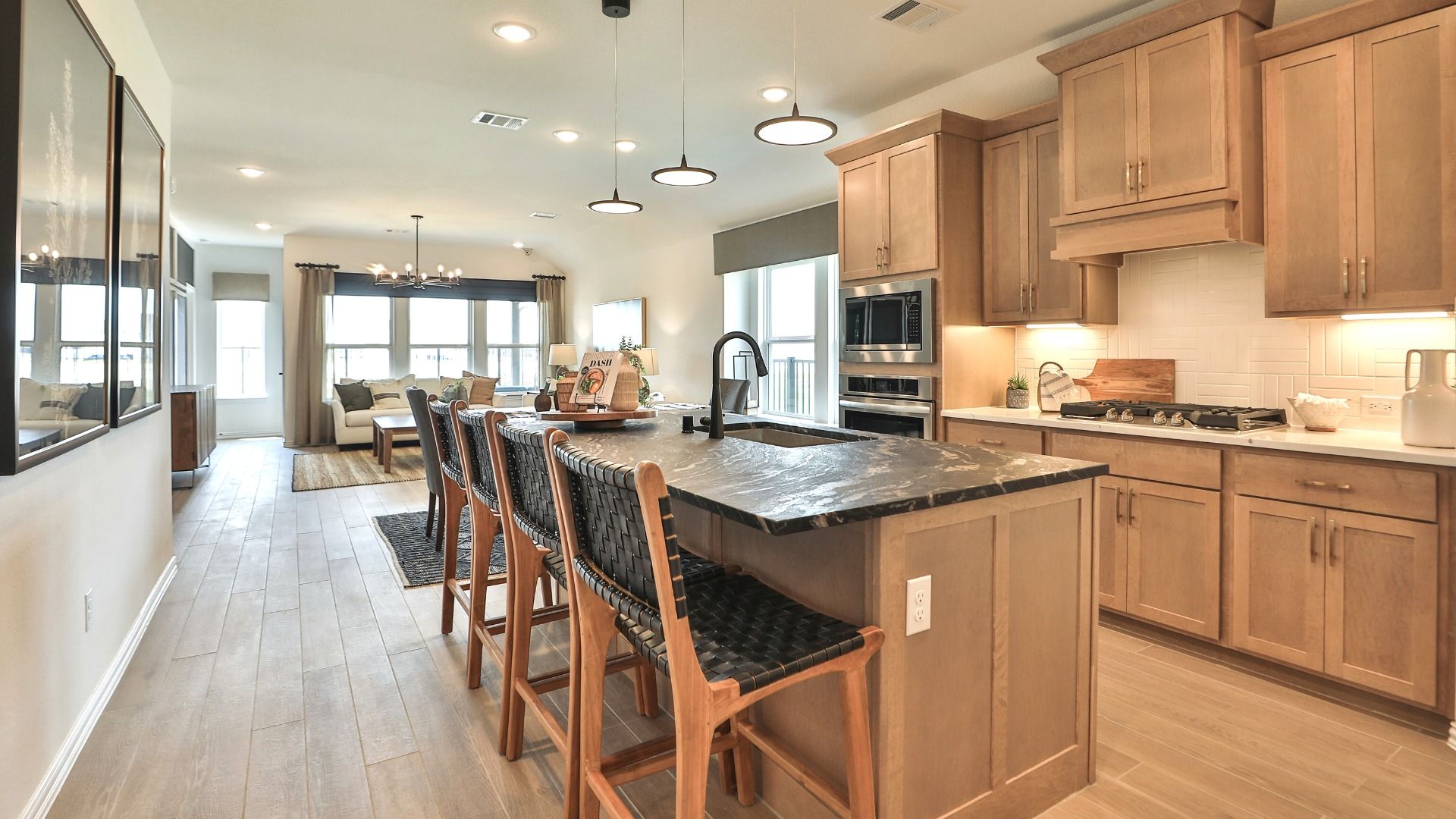 Exquisite Bridgeland home features a chic kitchen with luxurious stone countertops and sleek pendant lighting.