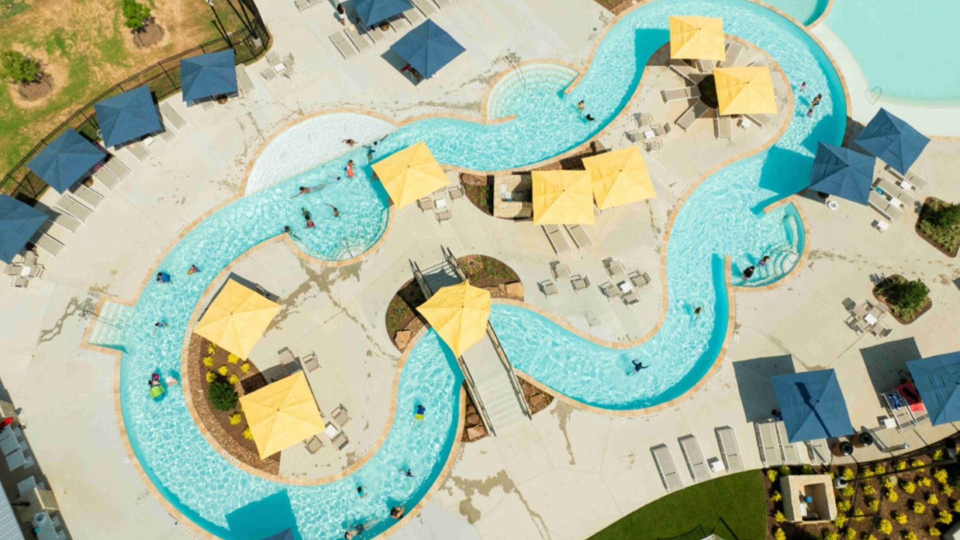 Experience luxury with Sunterra's elegant curving pool, featuring stylish umbrellas and serene lounging areas.