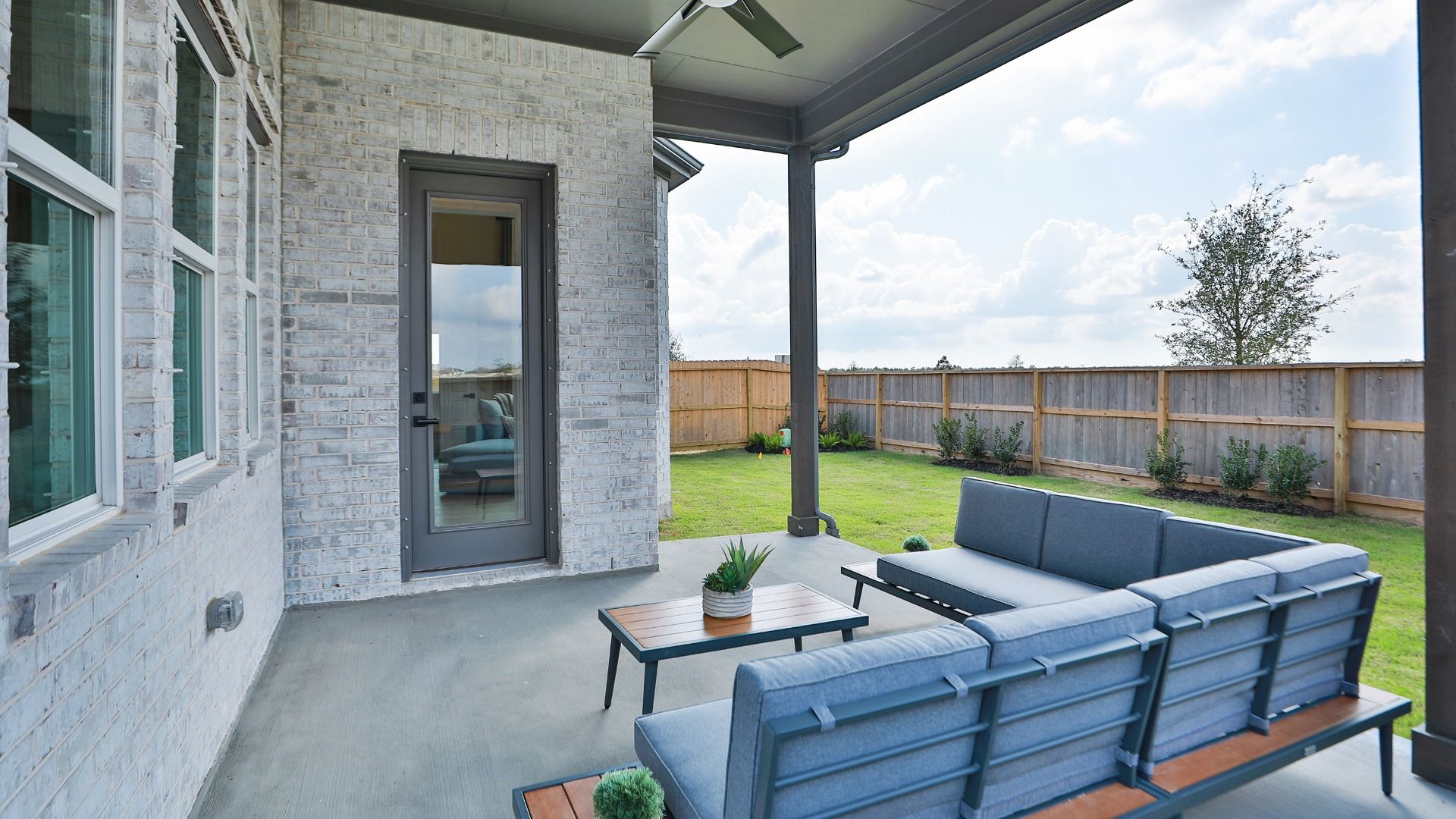 Covered patio with seating overlooking the private backyard space.