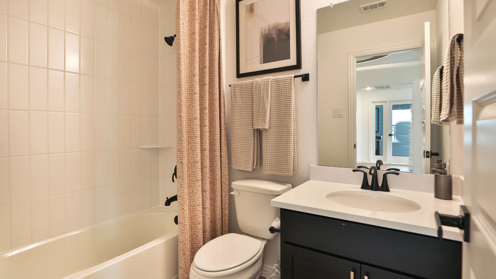Embrace understated elegance in Bridgeland's bathroom, showcasing a black vanity paired with modern matte fixtures.