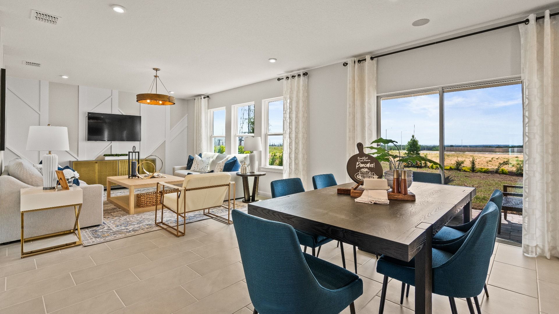 The Dining and Living Area in the Open Concept Model Highbourne by DRB Homes in Hamilton Bluff located in Haines City, FL.