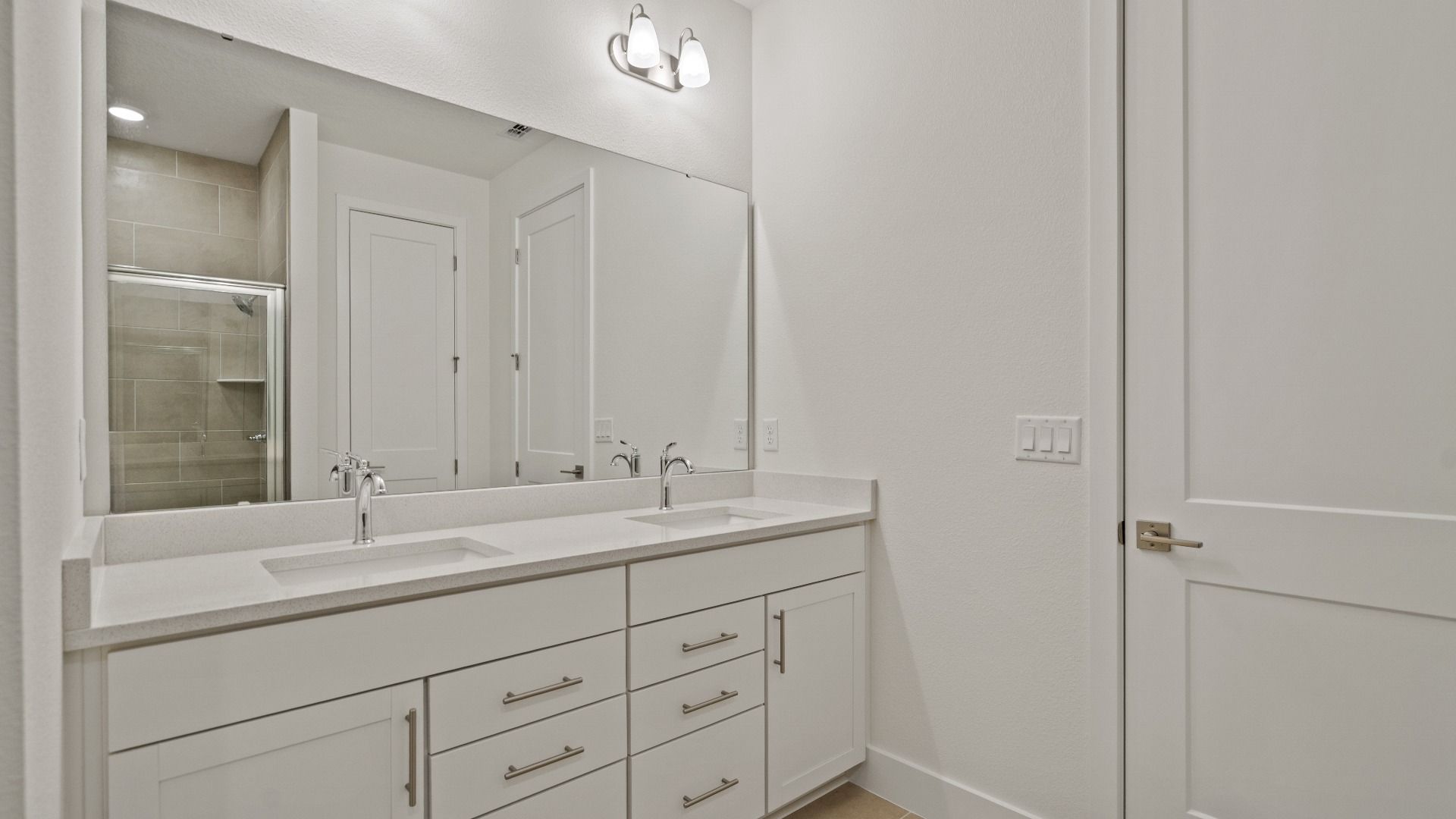 The Primary Suite en suite bath featuring dual bath sinks of the Buttonwood by DRB Homes at Trailside in Mount Dora, FL.