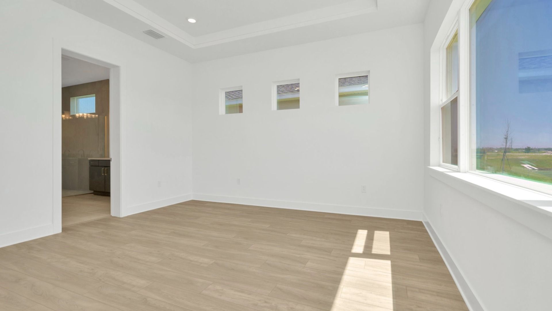 The Primary Bedroom of a DRB Homes Grand Hawk which is offered as a home plan at Serengeti in Spring Hill, FL.