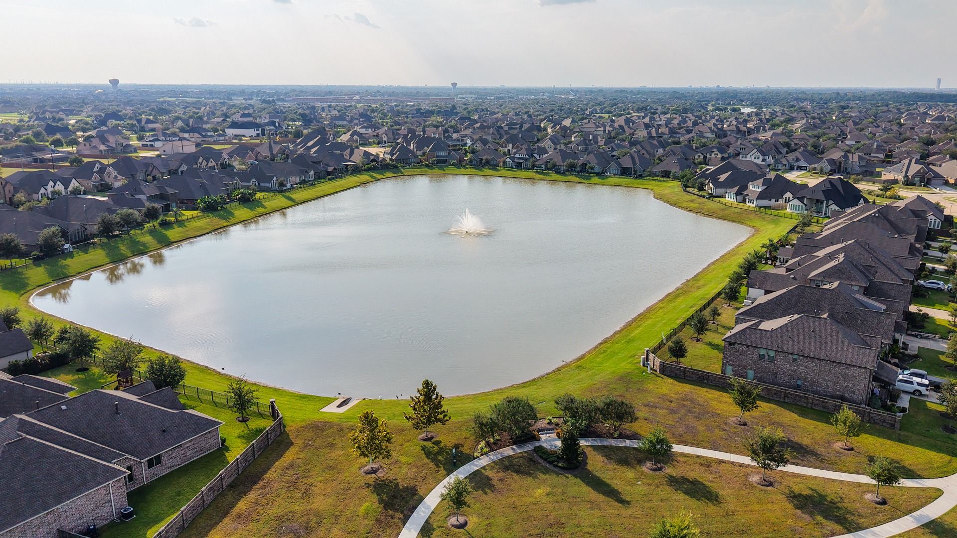 Elegant homes surround a tranquil pond with scenic walking trails in League City, Texas.