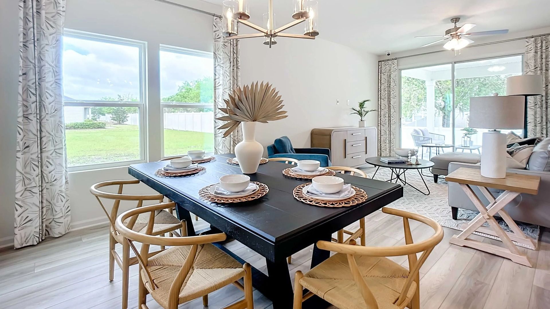 Luxurious dining space features a chic chandelier and expansive windows in Panther Creek.