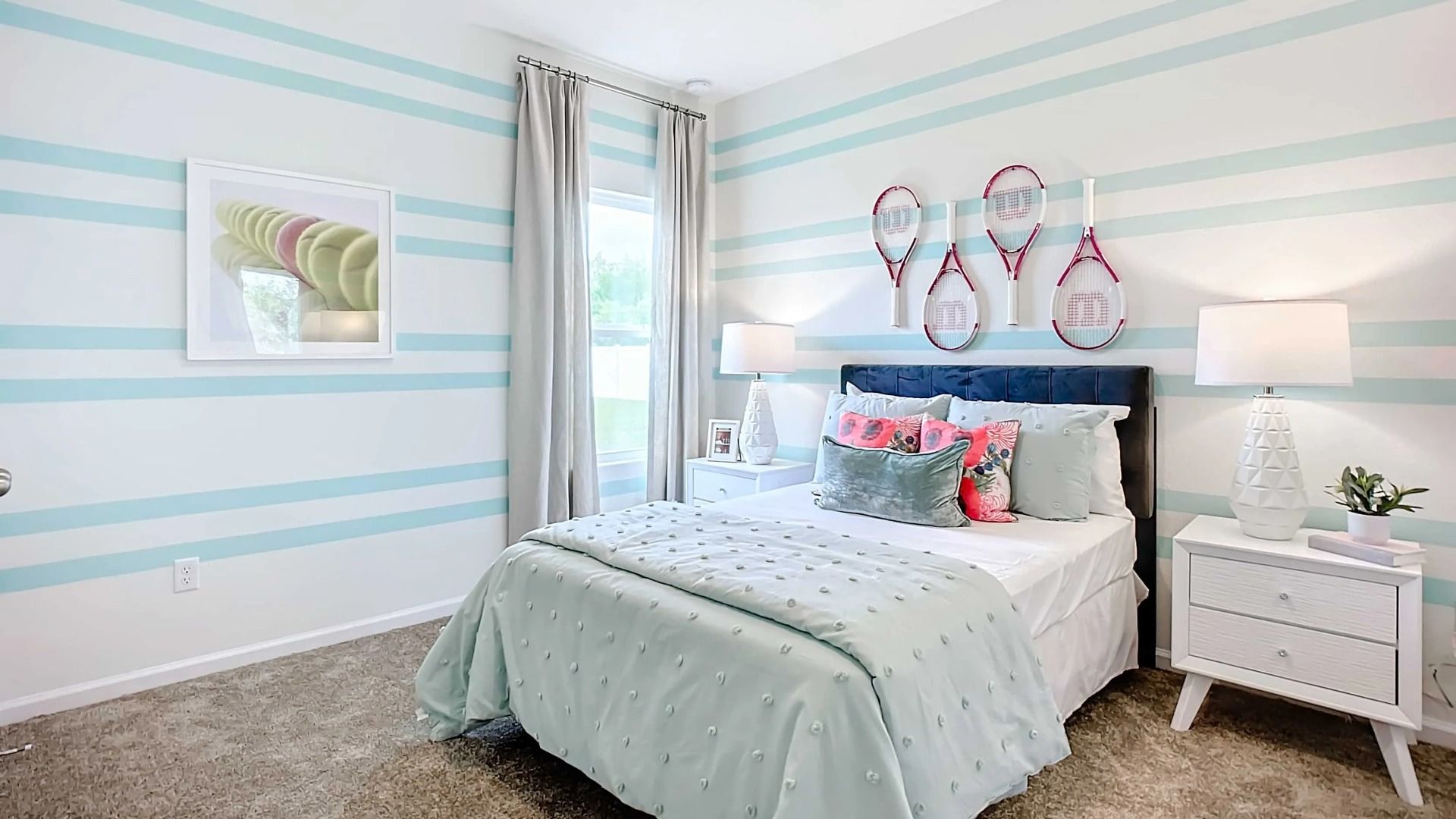 Elegant blue-striped walls and chic tennis theme elevate this Panther Creek bedroom in Jacksonville.