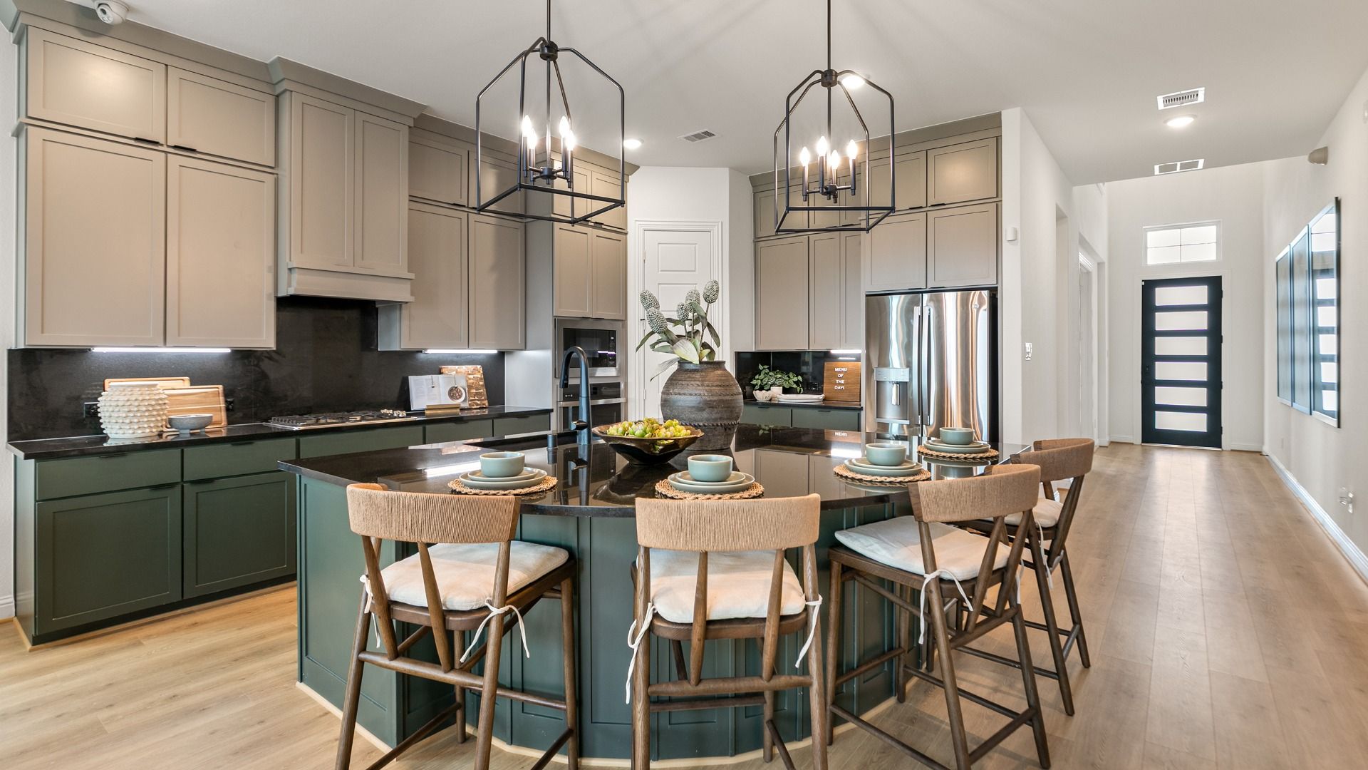 Kitchen featuring earthy sage cabinetry and dark bold counters.