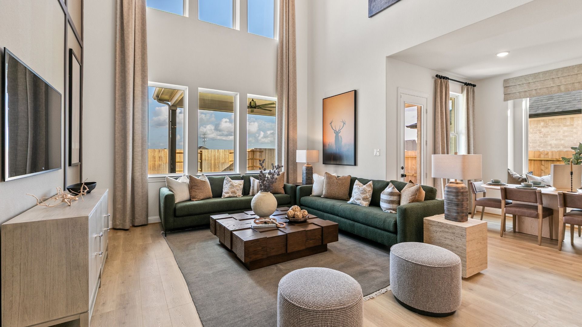 This grand family room features towering ceilings and expansive windows that fills the space with natural light.