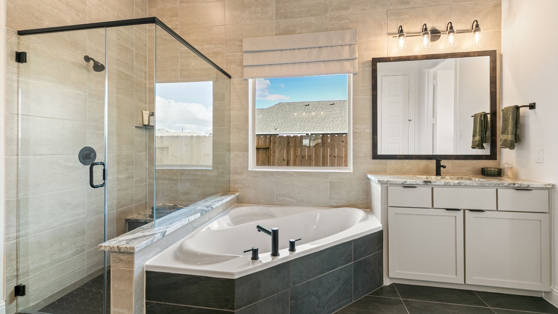 This spa-inspired bath in Creekhaven showcases a striking glass shower and dramatic tile wall.