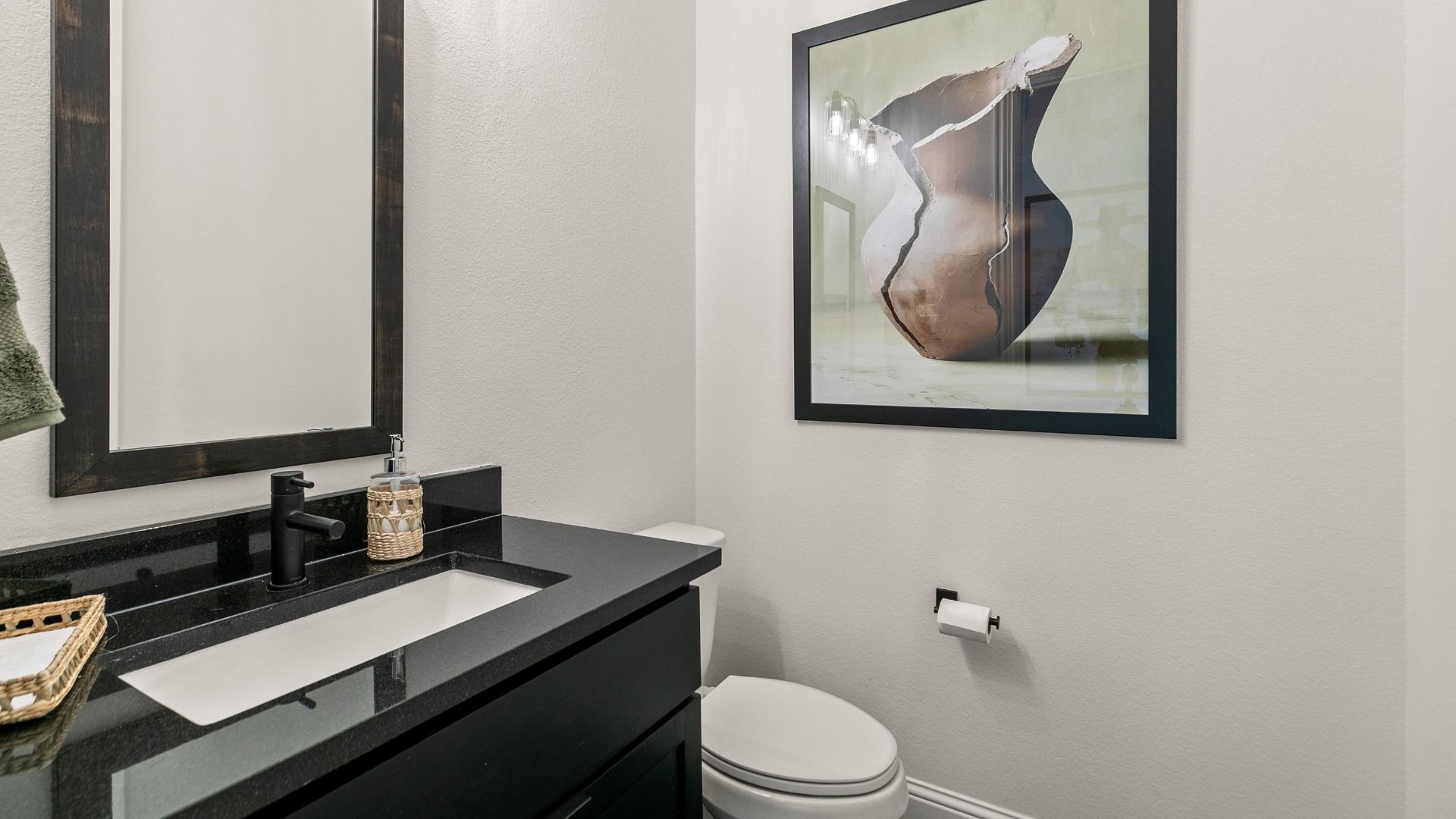 Dark cabinetry and rich countertops give this powder bath in Creekhaven a bold modern edge.