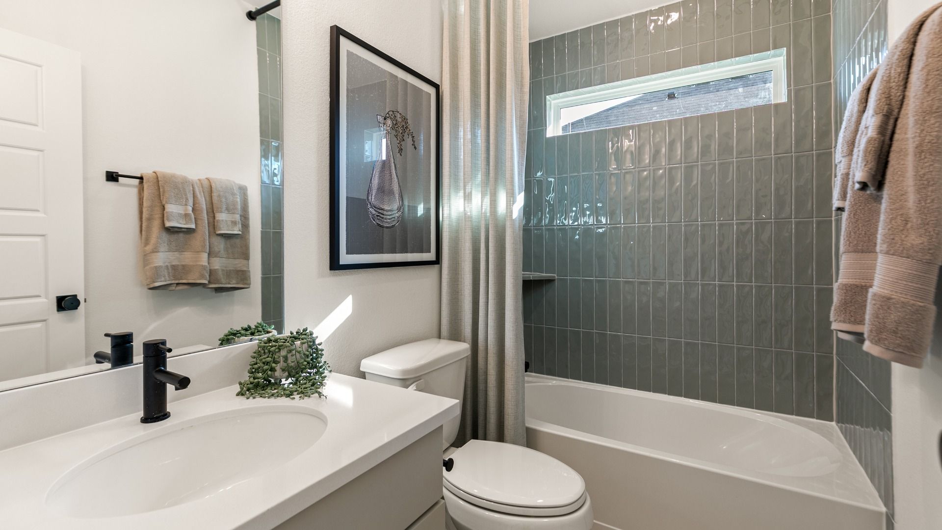 Sage green tile brings earthy depth to this bathroom in Creekhaven.