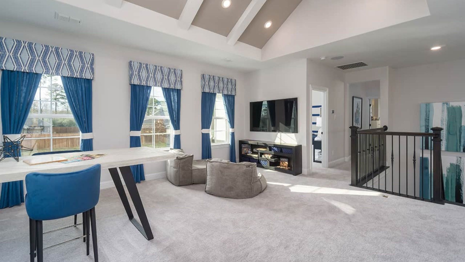 Sophisticated vaulted ceiling and vibrant blue drapery define this chic space in Mostyn Manor Reserve, Texas.