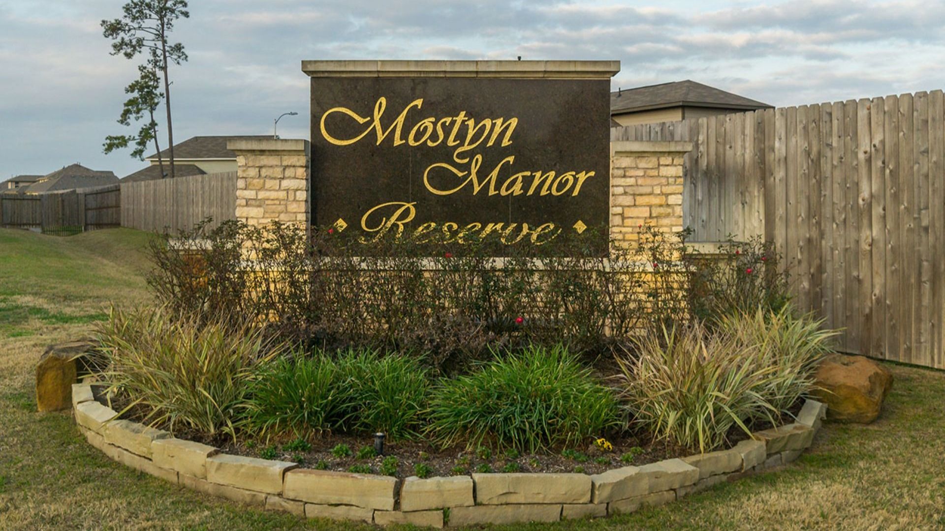 Elegant stonework and manicured landscaping mark the entrance to Mostyn Manor Reserve, offering refined living.