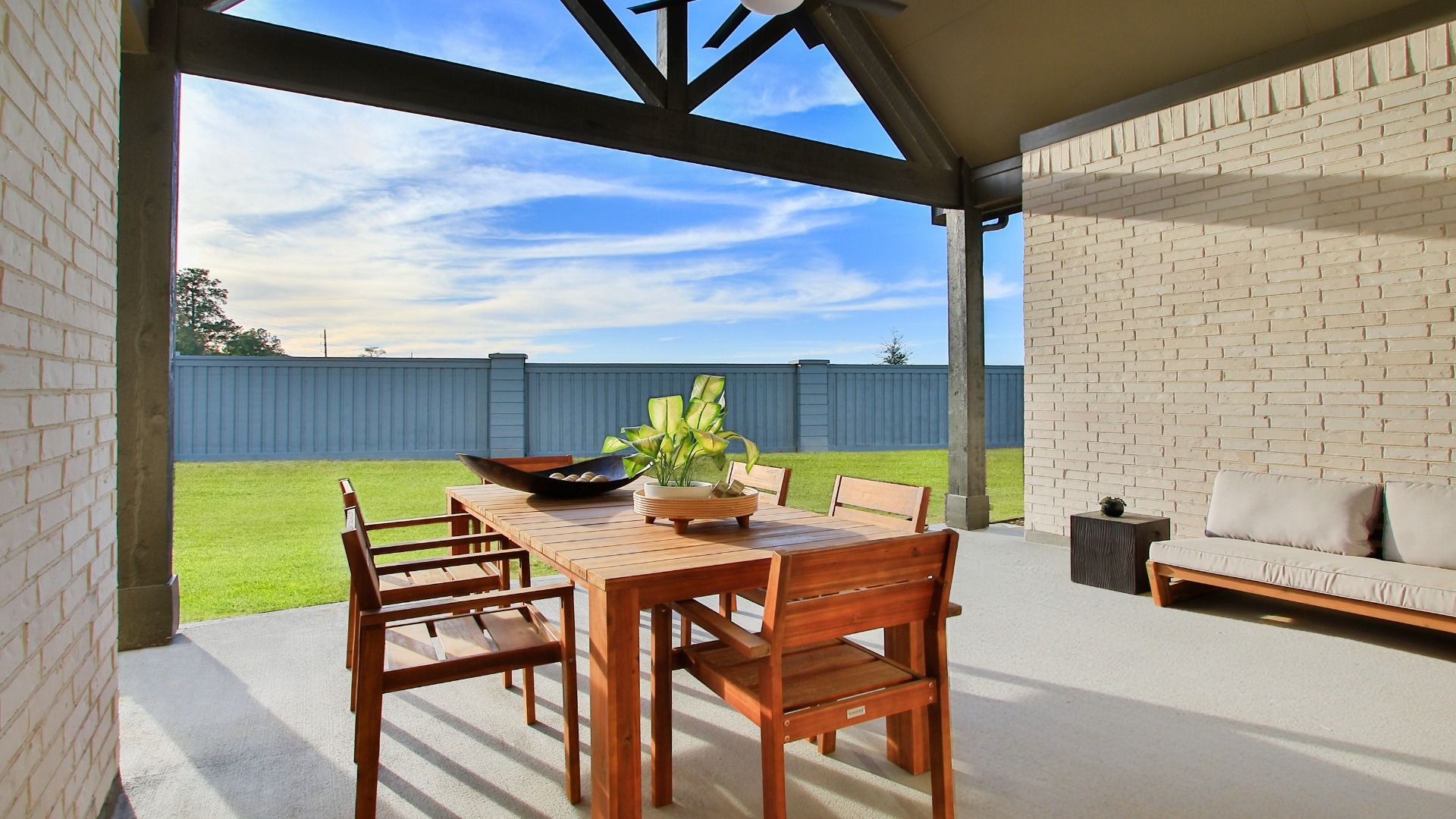 Expansive covered patio with room for dining and entertaining with views of the spacious backyard.