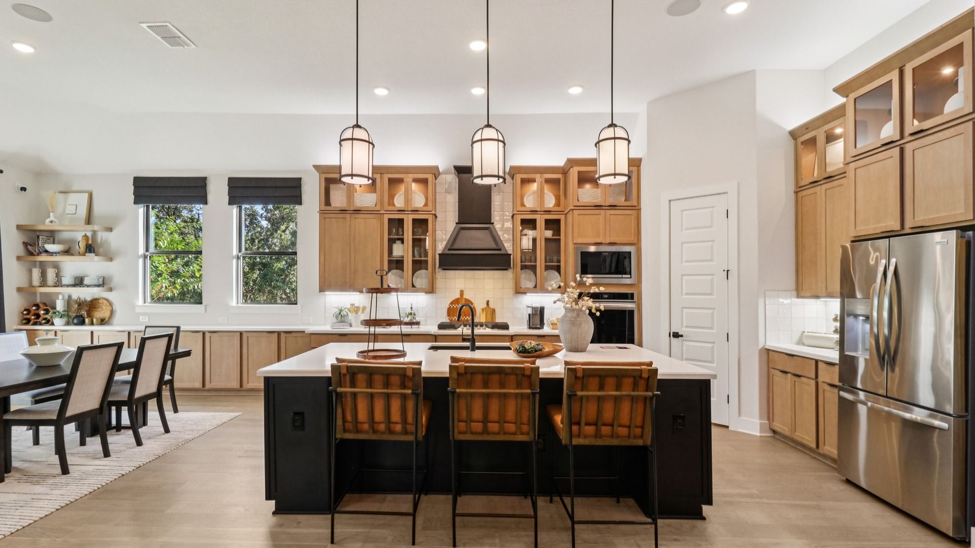 Elegant kitchen with wood flooring, chic island, and scenic windows in Verandas at the Rim.