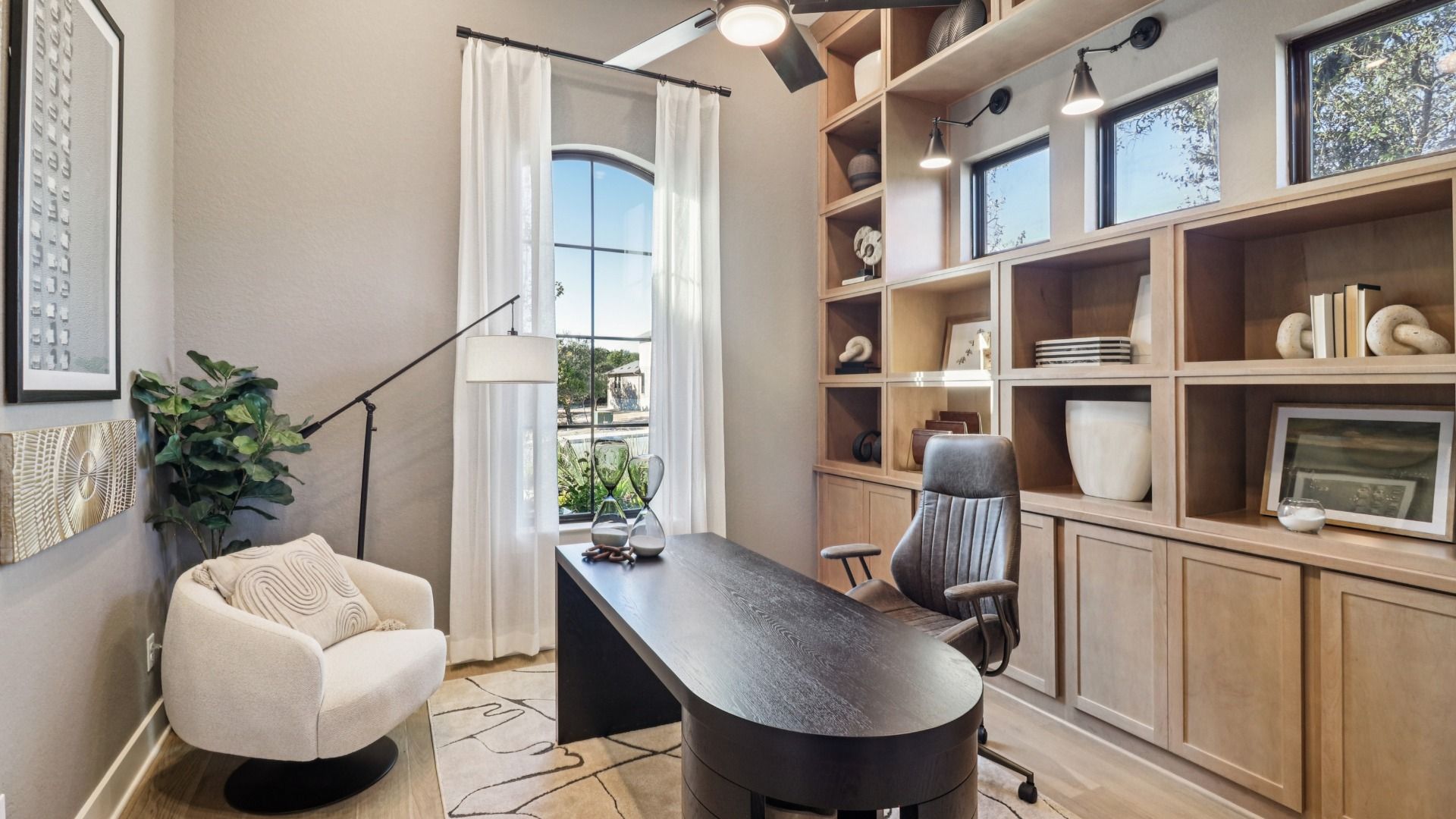 Custom wood shelving and expansive windows elevate this San Antonio office's refined design in Verandas at the Rim.