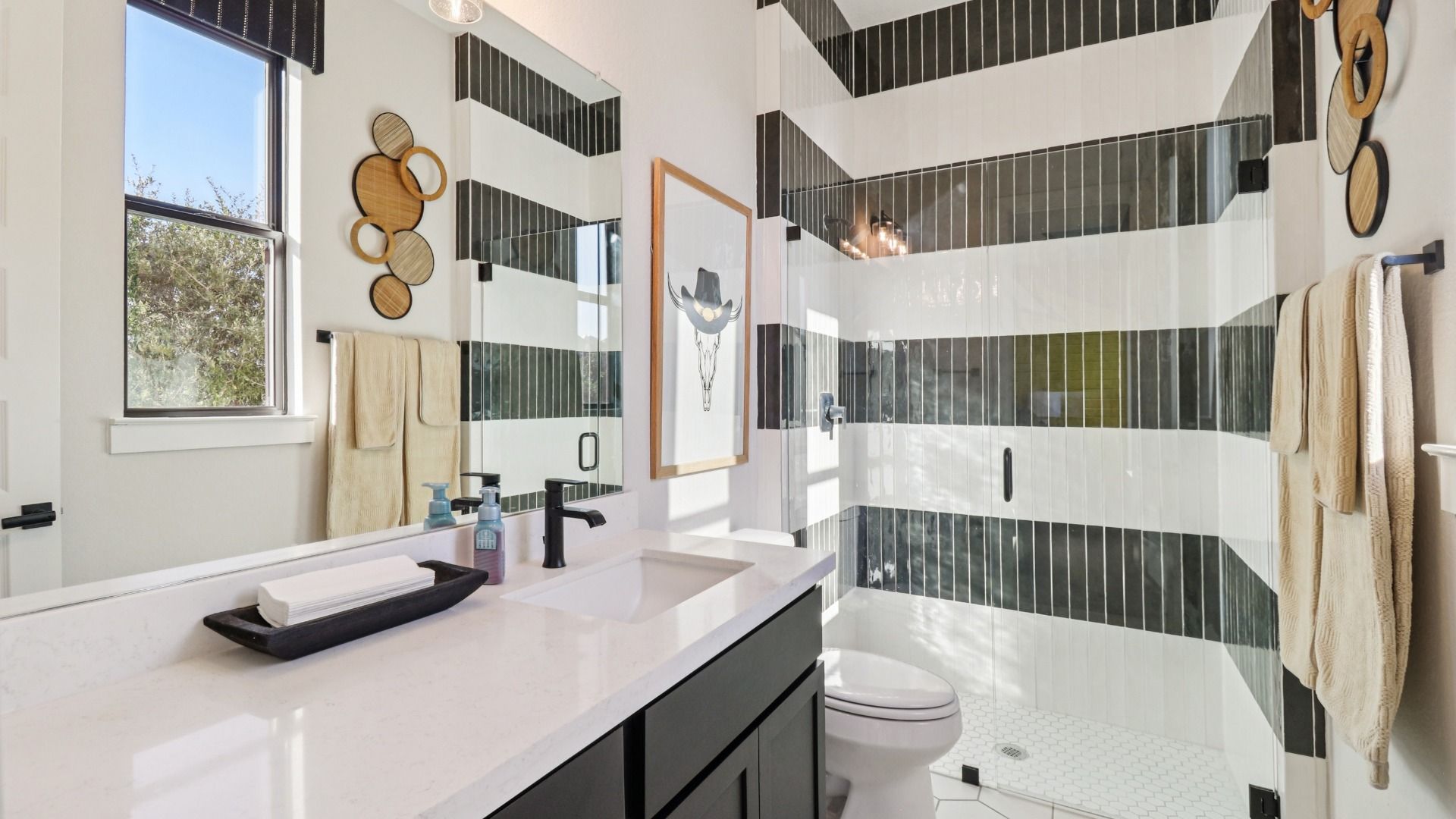 Elegantly designed striped tile shower with natural lighting enhances this sophisticated Verandas at the Rim bathroom.