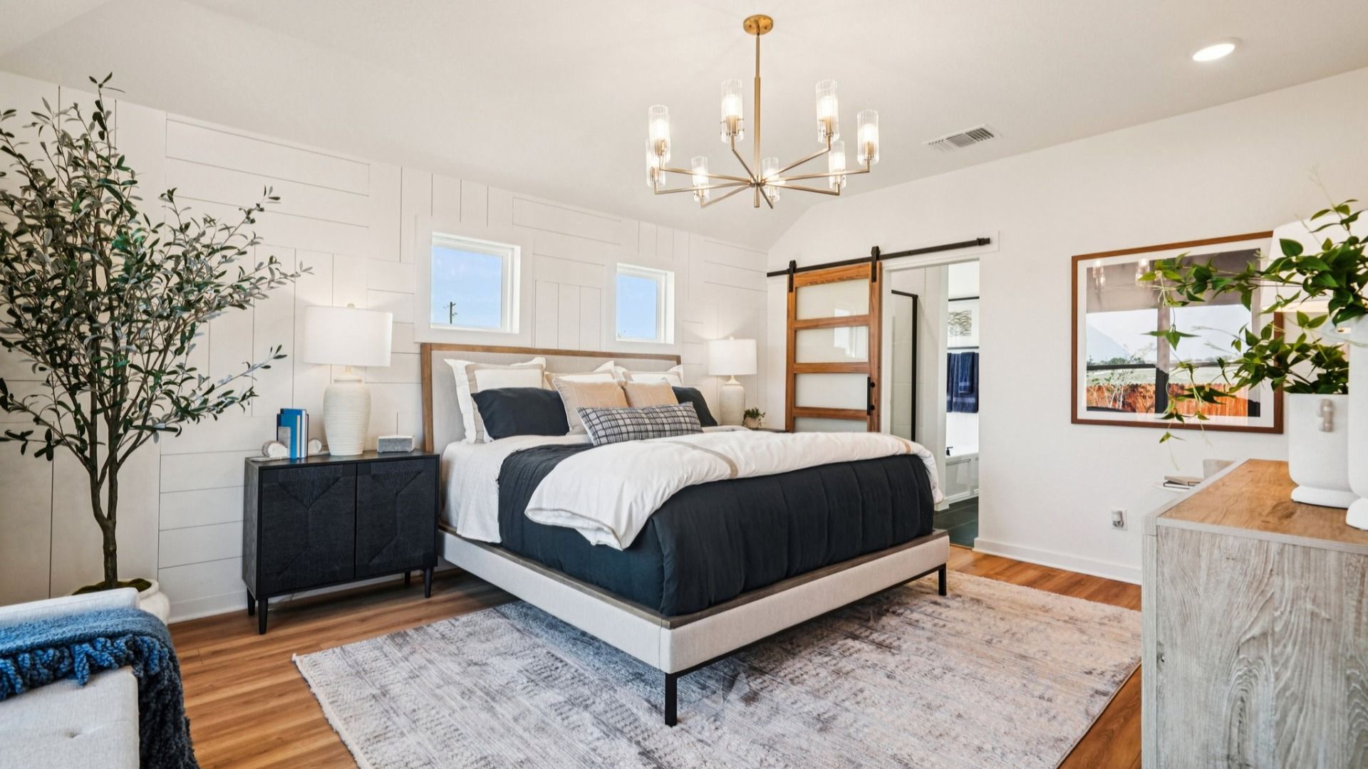 Owner's Suite is bright, with plenty of windows providing natural light, luxury vinyl floors, and woodwork on the walls