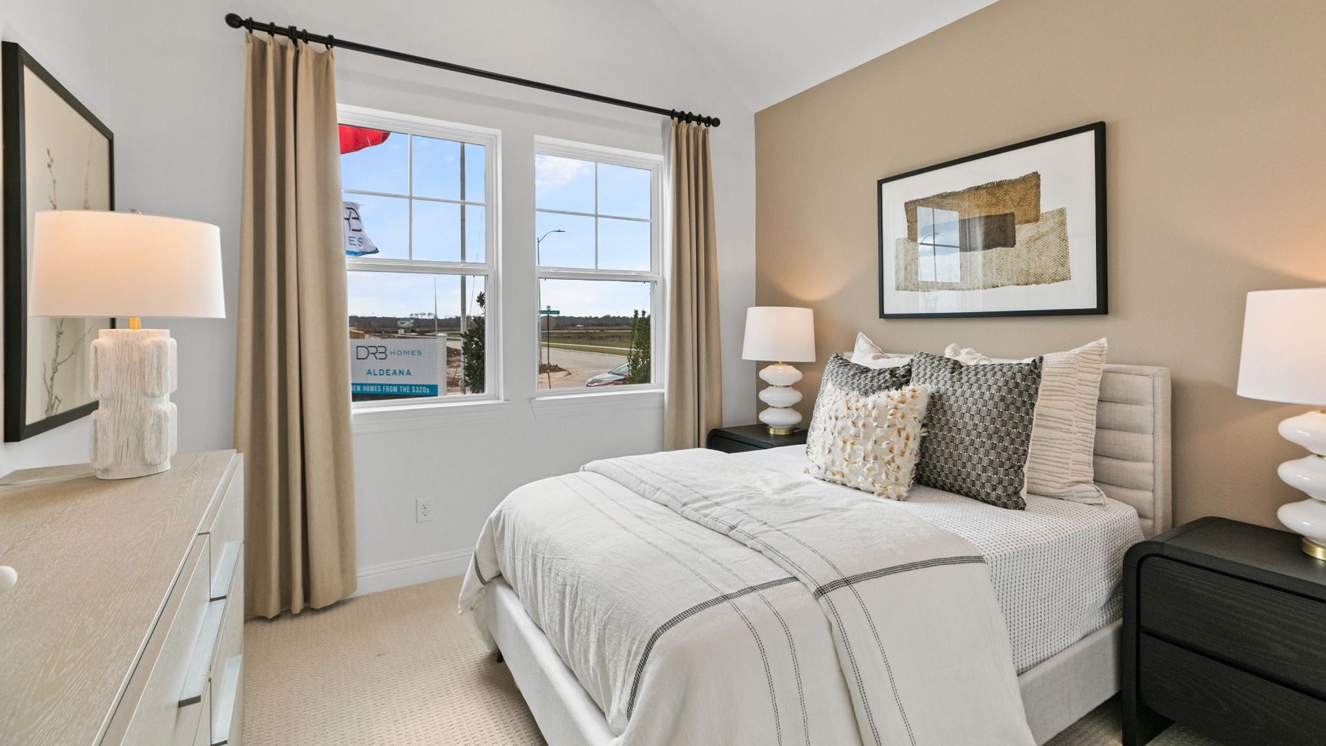 This spacious bedroom in Aldeana features expansive windows that enhance the airy design and bring beautiful natural light.