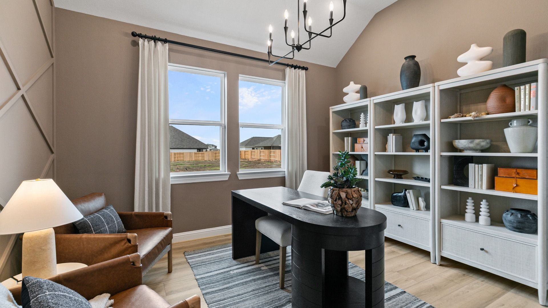 Geometric accent wall and large windows create a bright, modern study in this Aldeana home.