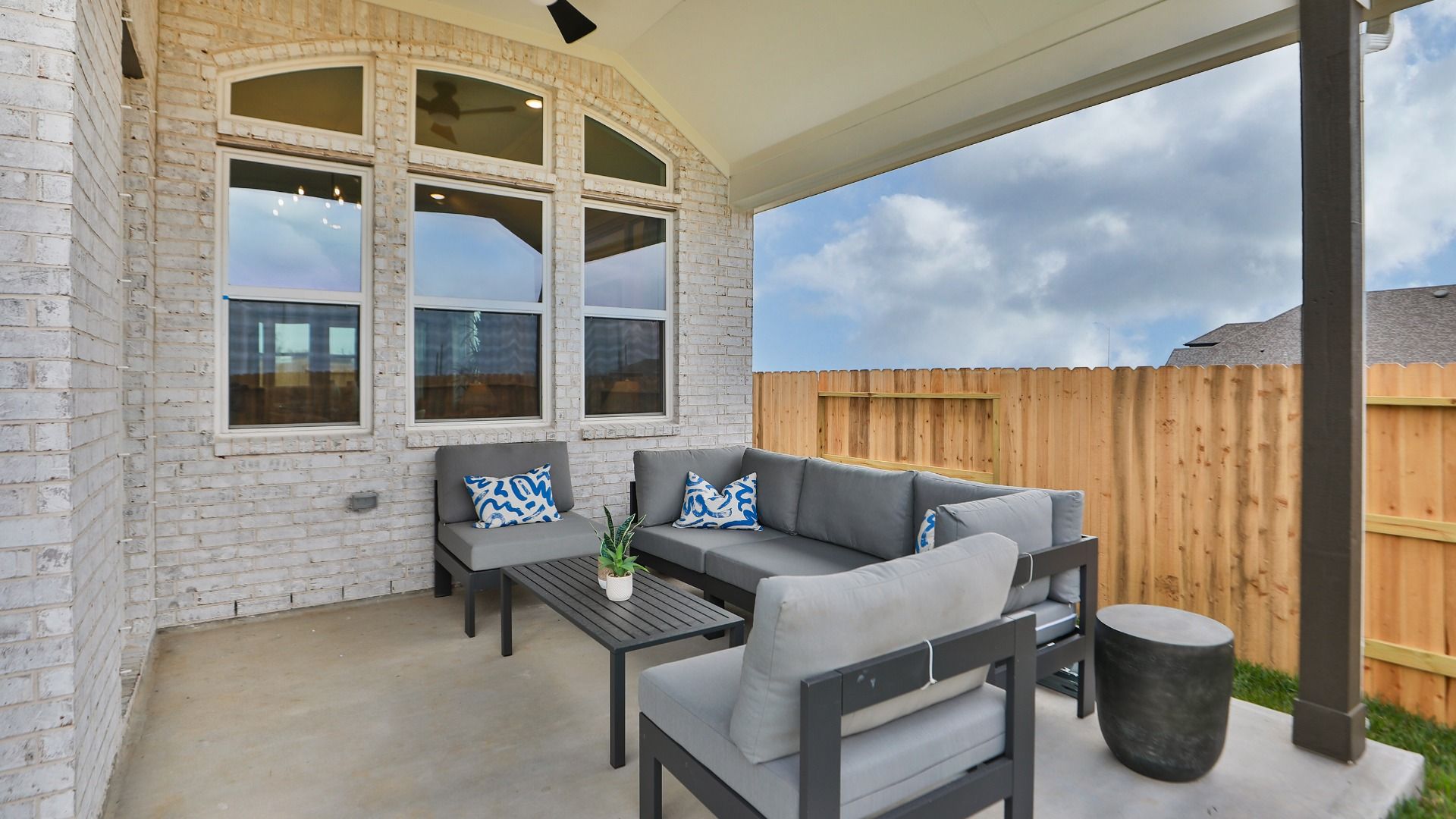 This covered patio in Aldeana offers comfortable seating and year-round outdoor living.