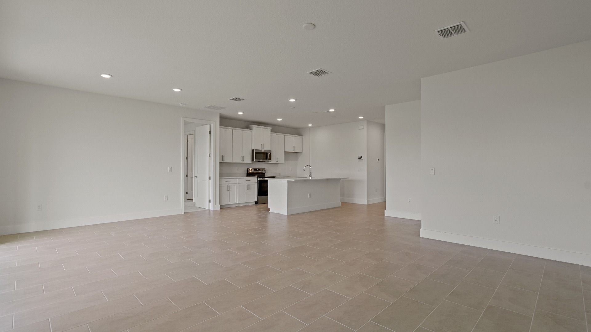 Living Area and Kitchen in the Buttonwood floorplan by DRB Homes at Lakeside at Satilla in Saint Cloud, FL