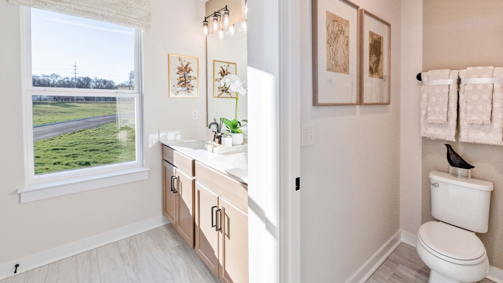 Bright Primary bathroom with dual-sink vanity and private water closet