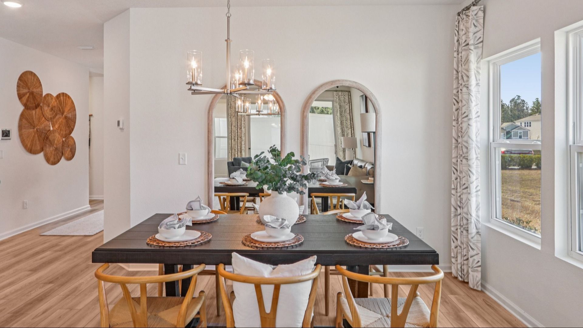 Luxurious dining space features a chic chandelier and expansive windows in Panther Creek.