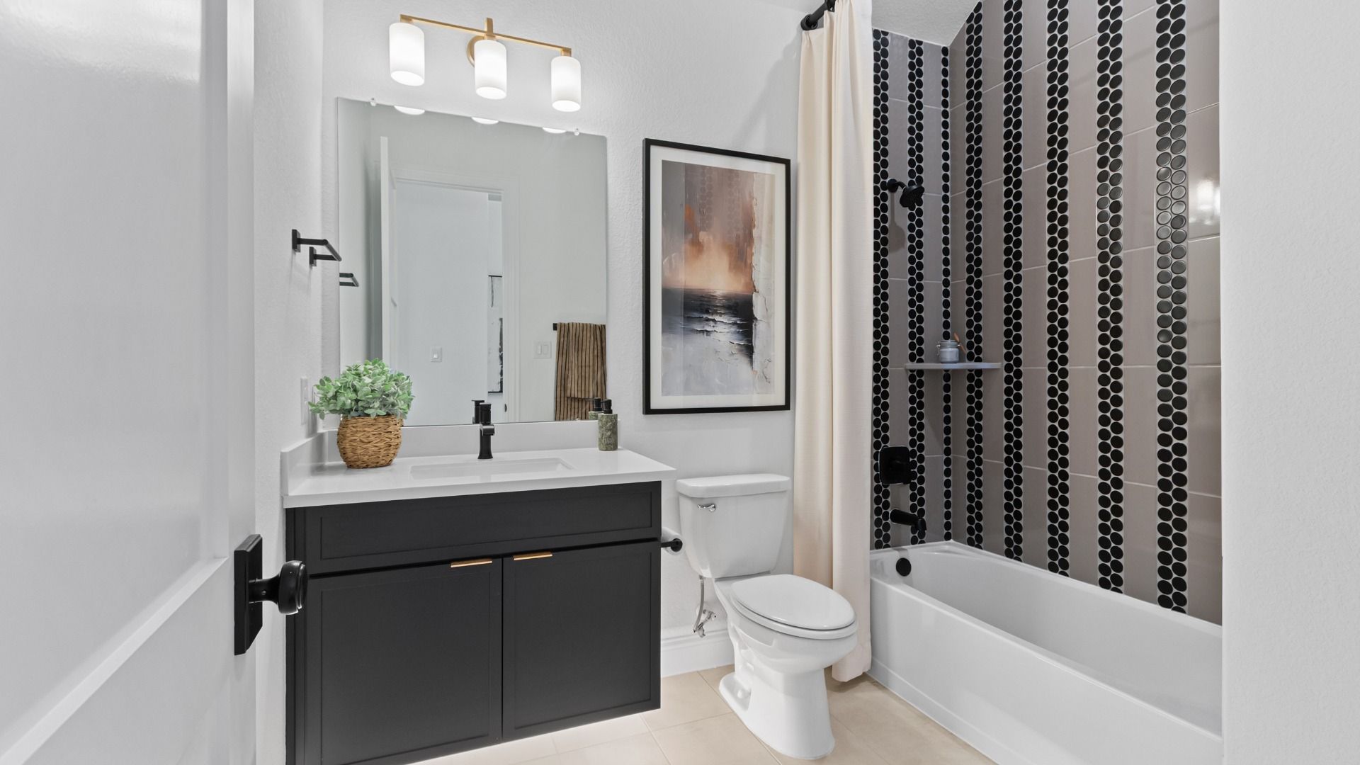 A stylish secondary bathroom featuring dark accents and unique tile design for a modern edge in Wildrye.