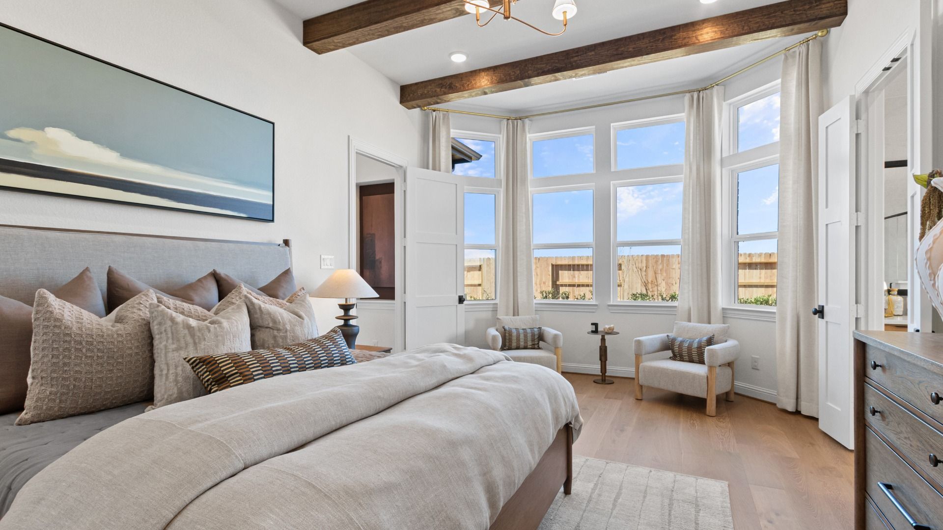 A spacious primary bedroom featuring beautiful bay windows that fill the room with natural light.