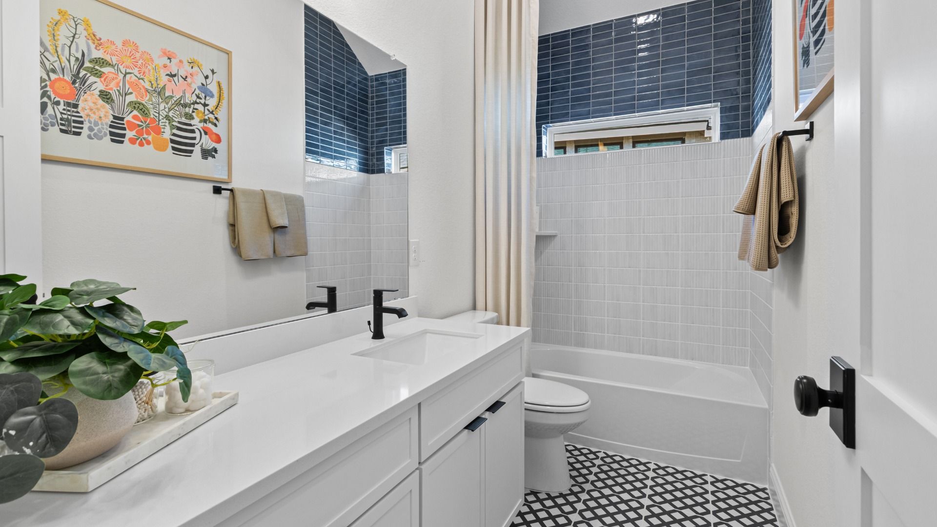 Beautiful tile design paired with bright white cabinetry and countertops in this stylish secondary bathroom.