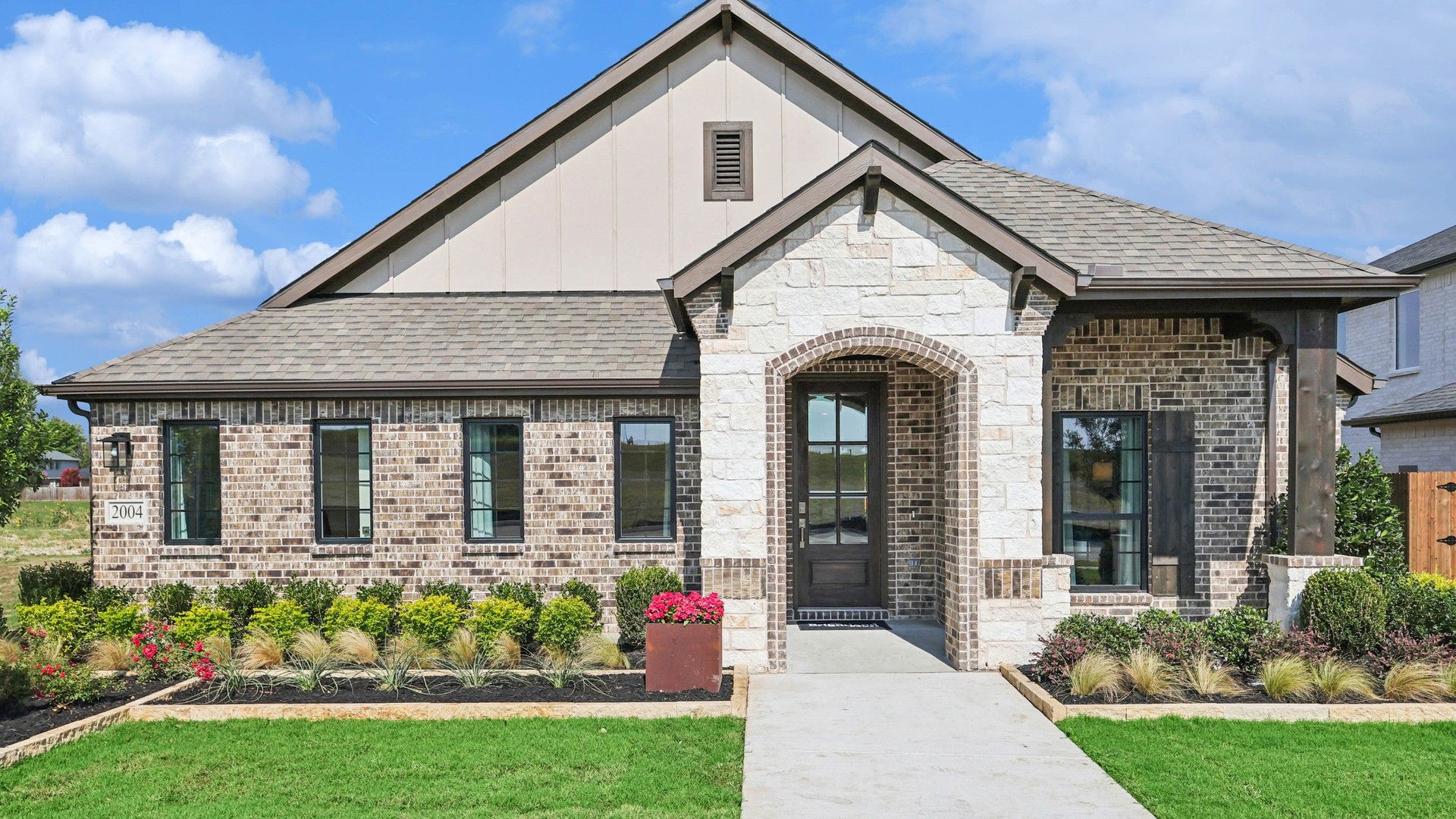 Elegant brick facade with a stone archway and manicured landscaping in prestigious Pebblebrook community.