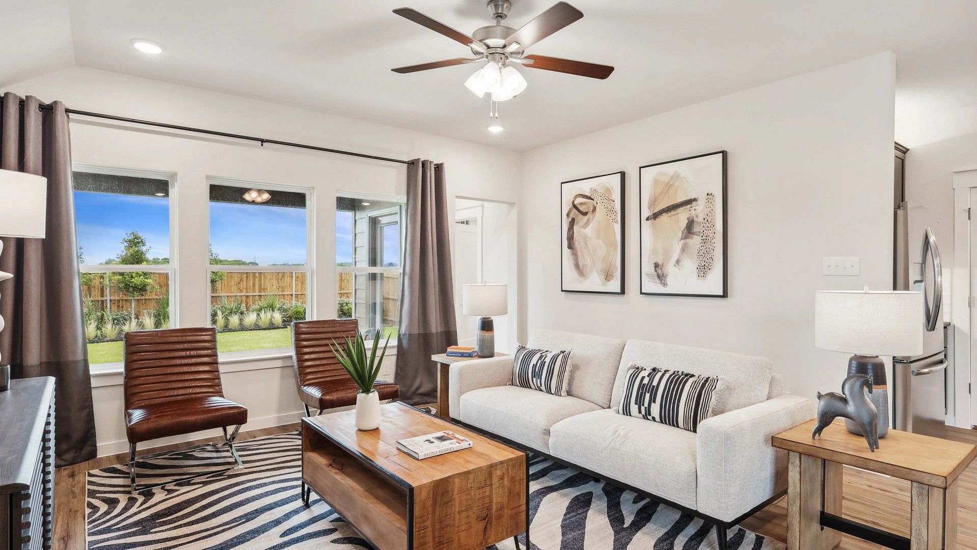 Elegant zebra rug, abstract art, and wood accents enrich this Simpson Crossing living room.
