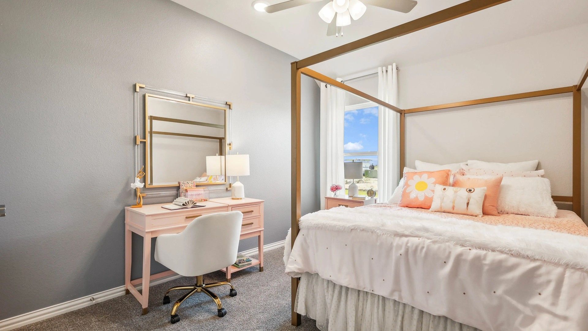 Pebblebrook bedroom features luxurious pink vanity, gold accents, plush bedding, and elegant ceiling fan.